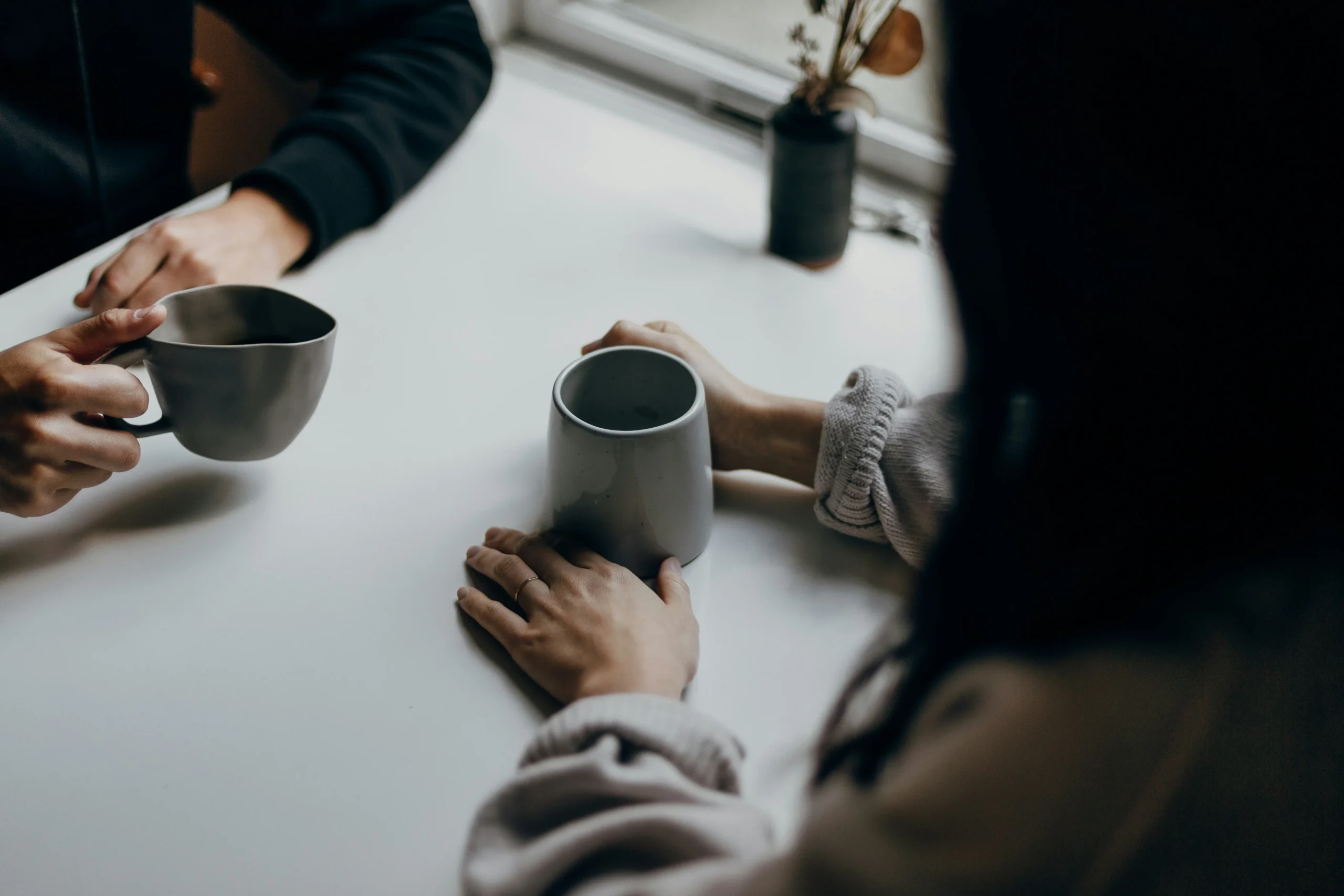 Image de deux personnes attablées autour d'un café qui échangent pour illustrer l'échange thérapeutique dans le cadre d'une thérapie abordable