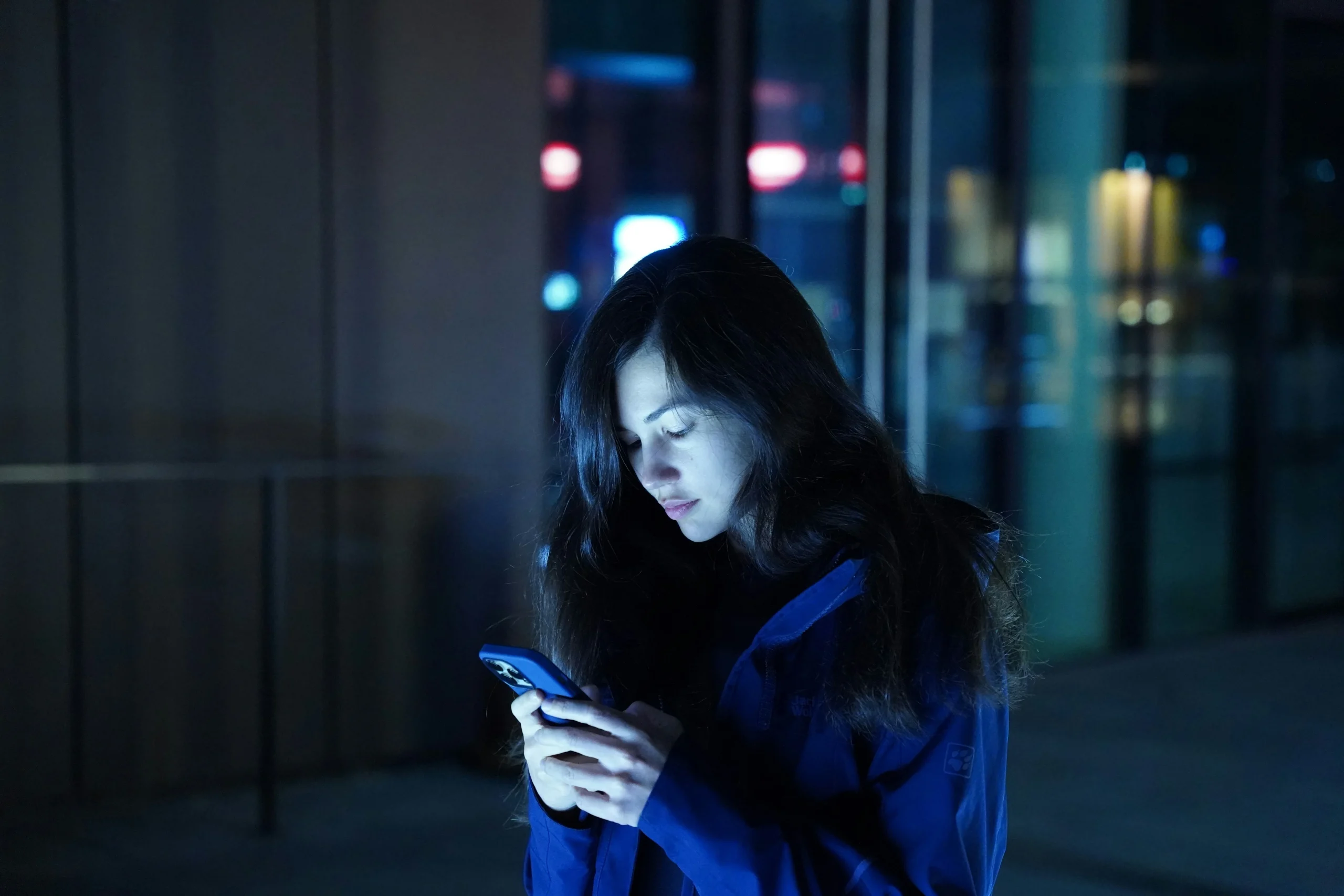 Jeune personne regardant son portable, tard le soir, illustrant l'addiction aux réseaux sociaux